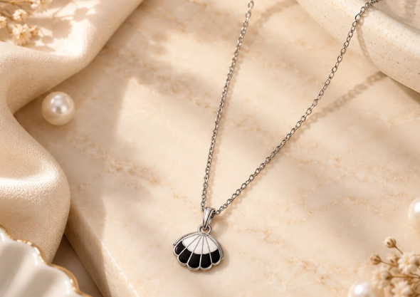 Black Enamel Shell Pendant Chain. A silver-tone chain with a black enamel shell pendant.