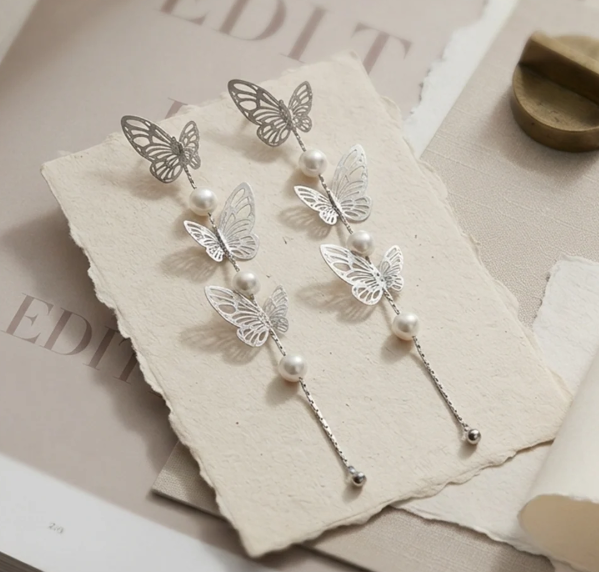 Butterfly Pearl Long Drop Earrings in Silver. Delicate filigree butterflies and pearls cascading on a long fine chain.
