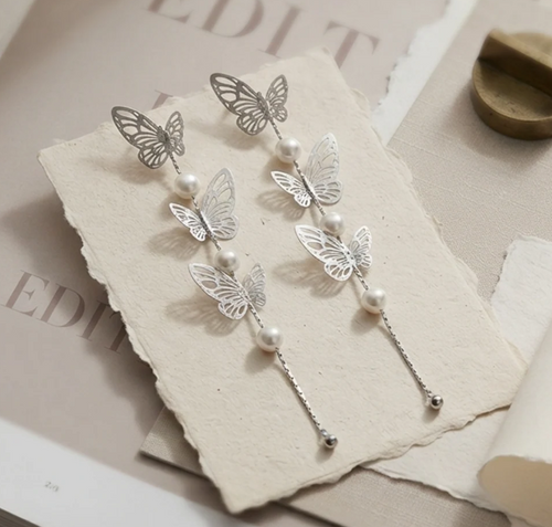 Butterfly Pearl Long Drop Earrings in Silver. Delicate filigree butterflies and pearls cascading on a long fine chain.