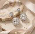 Flower Cage Crystal Drop Earrings in Silver. A rounded flower-shaped cage studded with crystals, on a solitaire stud top.