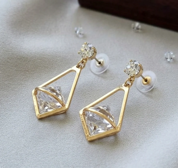 Gold Kite Cage Crystal Drop Earrings. A crystal suspended in an open gold kite-shaped frame, hanging from a solitaire stud.