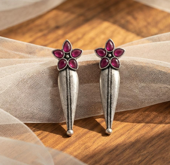 Flower Stud Silver Drop Earrings in Ruby Pink. Oxidised silver-finish earrings with a five-petal stone flower stud and a long textured teardrop drop with a beaded centre line.