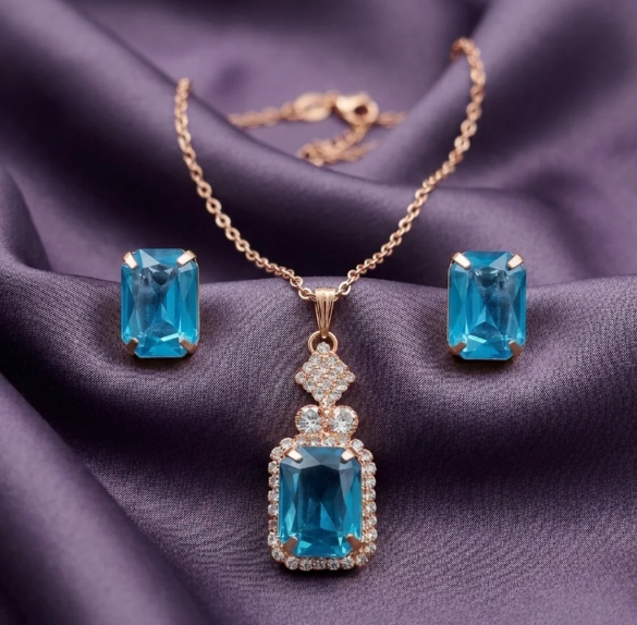Aqua Blue Pendant Necklace Set. An emerald-cut aqua-blue pendant framed in crystals, with matching stud earrings.
