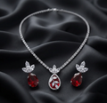 Ruby Teardrop Crystal Necklace Set. A crystal tennis chain with a ruby-red teardrop centrepiece and matching earrings.