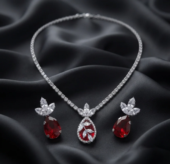 Ruby Teardrop Crystal Necklace Set. A crystal tennis chain with a ruby-red teardrop centrepiece and matching earrings.